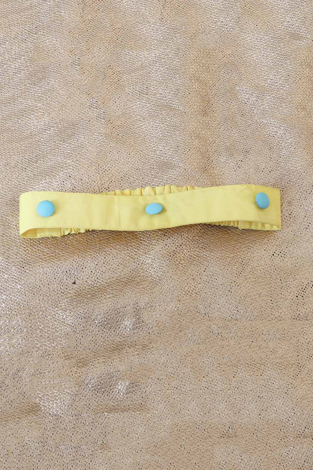 Yellow headband with blue beads attached